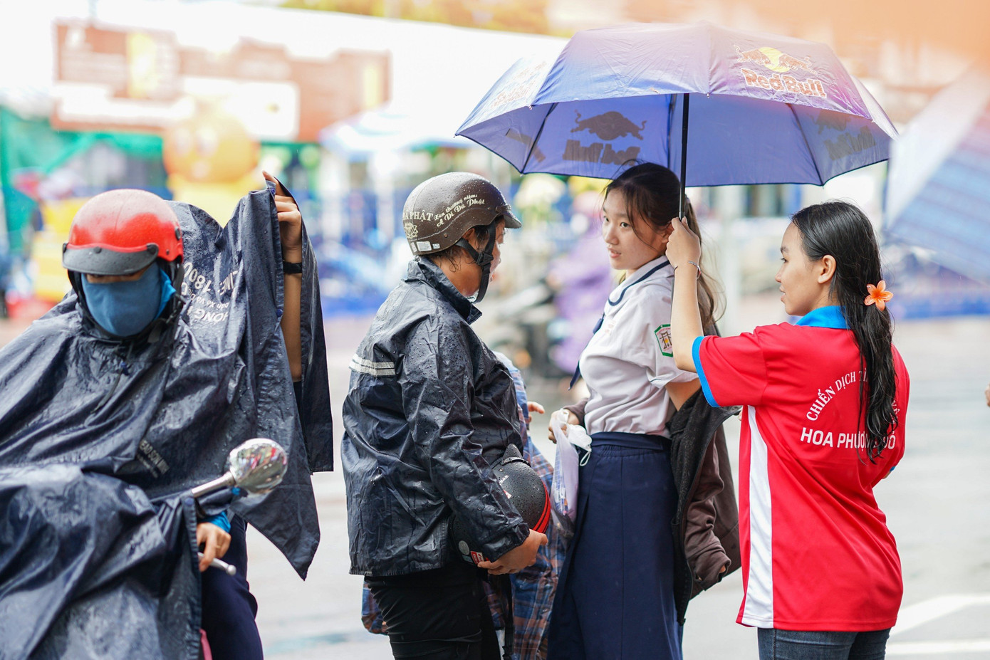 Ghi nhận tại điểm thi trường THPT Mạc Đĩnh Chi (Q. 6) trong buổi chiều thi môn Toán, do trời mưa nên nhiều sĩ tử khi bước vào phòng thi đã được các tình nguyện viên hỗ trợ che ô.