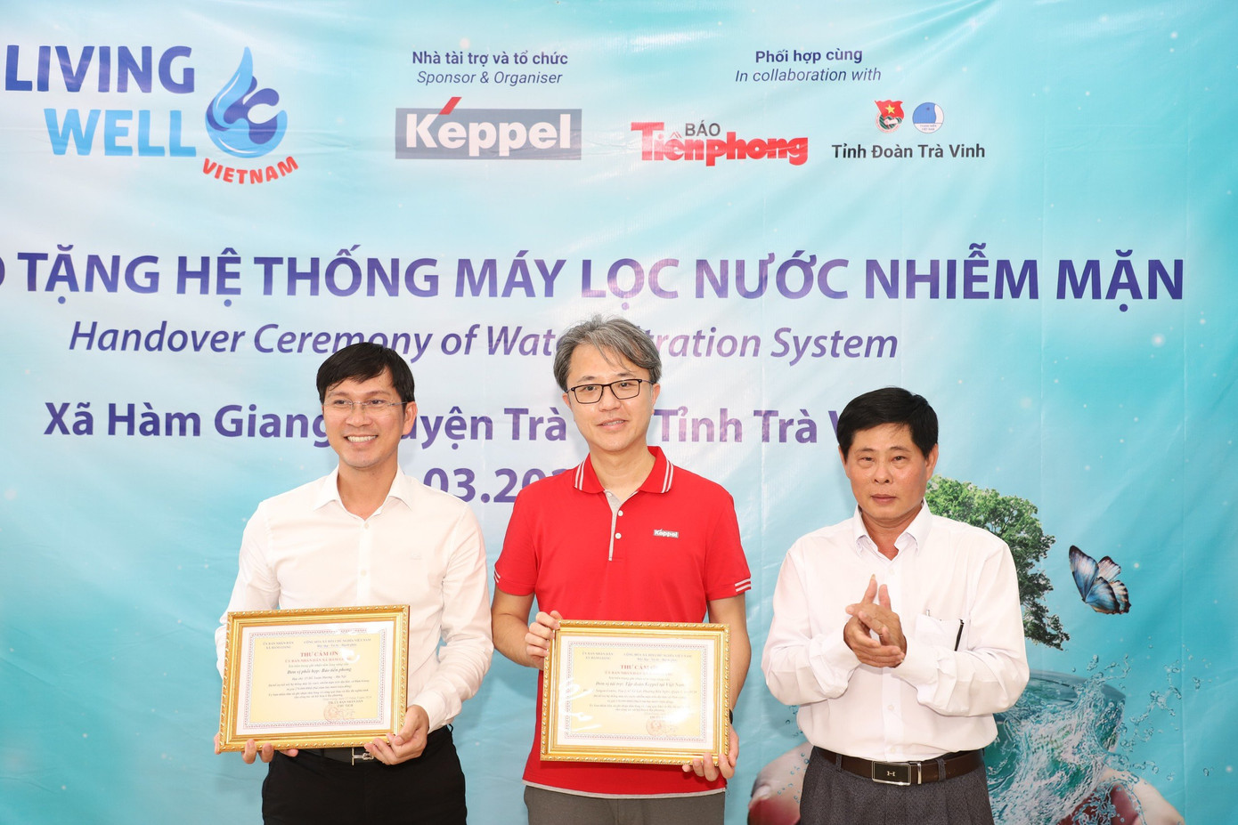 Lãnh đạo địa phương xã Hàm Giang (Trà Cú, Trà Vinh) trao thư cảm ơn cho đại diện báo Tiền Phong và đại diện Tập đoàn Keppel tại Việt Nam. (Ảnh: Ngô Tùng)