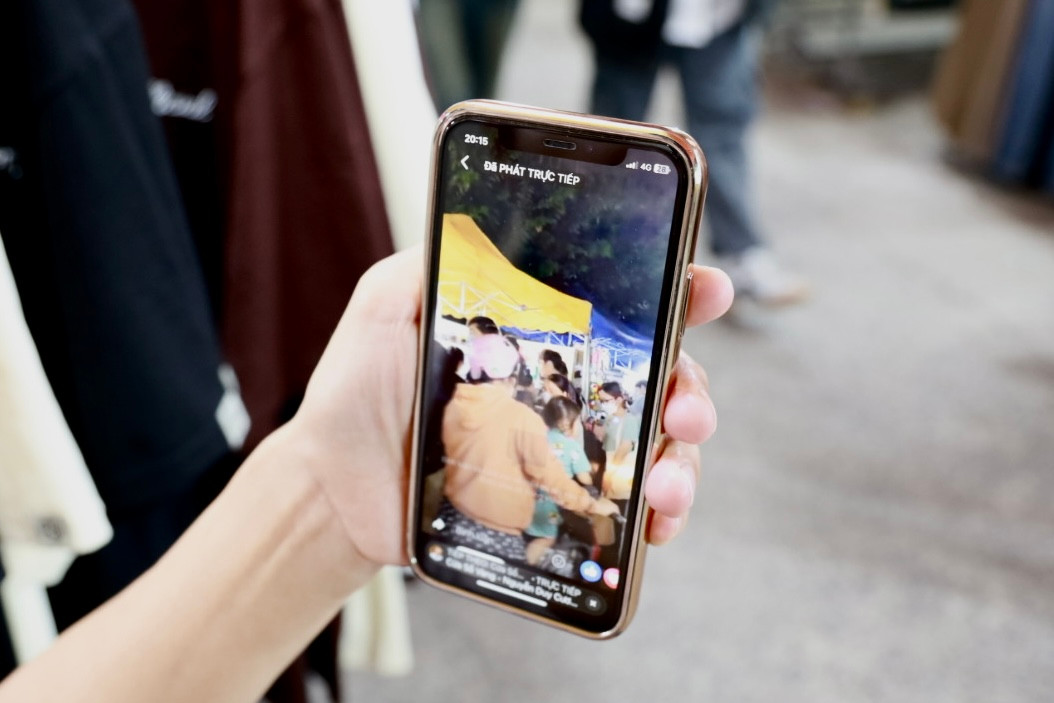 Chị Phượng xem lại lần livestream năm ngoái, người mua hàng ghé quầy tấp nập. (Ảnh: Thùy Trân)