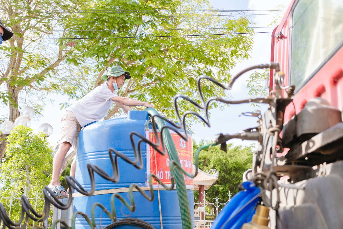 Người dân địa phương hỗ trợ nhóm sinh viên di chuyển nước vào gần nơi nhà dân sinh sống. (Ảnh: NVCC)