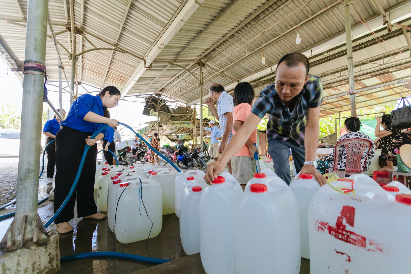 Người dân ở địa phương lấy nước do đoàn sinh viên hỗ trợ. (Ảnh: NVCC)