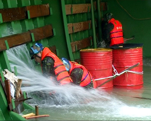 Phía mạn trái trong hầm hàng của tàu bị hỏa lực máy bay địch bắn thủng, các chiến sĩ đang tích cực tìm mọi biện pháp chống chìm tàu