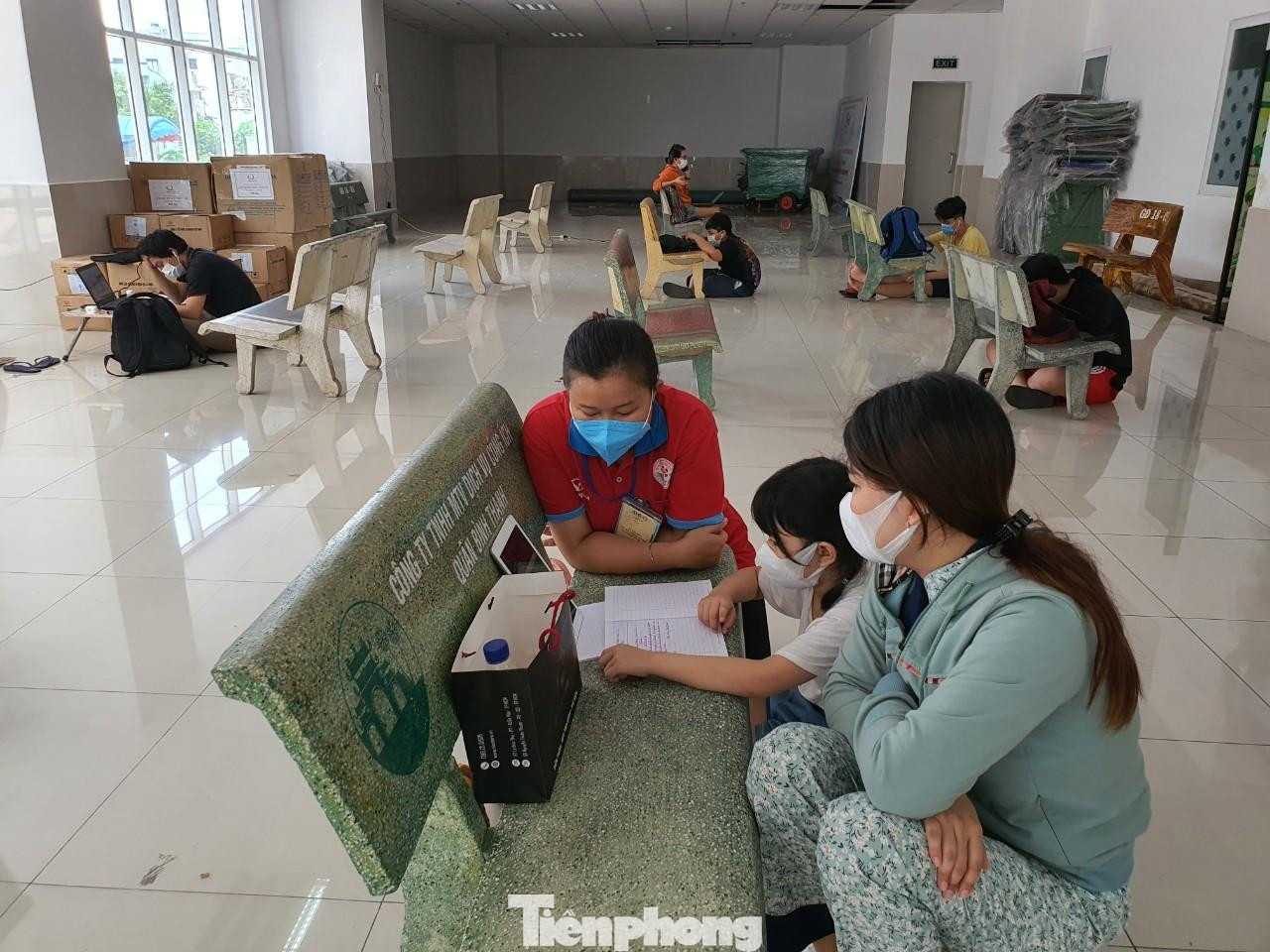 “Do người dân thuộc đối tượng khó khăn và chỉ ở tạm nên hầu hết không có điều kiện lắp đặt internet hoặc mua các gói cước 3G, 4G tốc độ cao trong khi năm học mới đã bắt đầu. Do đó, Tổ phụ trách ở chung cư đã tận dụng sảnh block A, đề xuất lắp wifi để làm một lớp học "dã chiến”, đại úy Sỹ nói. Trong ảnh: Phụ huynh và cán bộ hỗ trợ các em nhỏ học online. “Do người dân thuộc đối tượng khó khăn và chỉ ở tạm nên hầu hết không có điều kiện lắp đặt internet hoặc mua các gói cước 3G, 4G tốc độ cao trong khi năm học mới đã bắt đầu. Do đó, Tổ phụ trách ở chung cư đã tận dụng sảnh block A, đề xuất lắp wifi để làm một lớp học "dã chiến”, đại úy Sỹ nói. Trong ảnh: Phụ huynh và cán bộ hỗ trợ các em nhỏ học online.