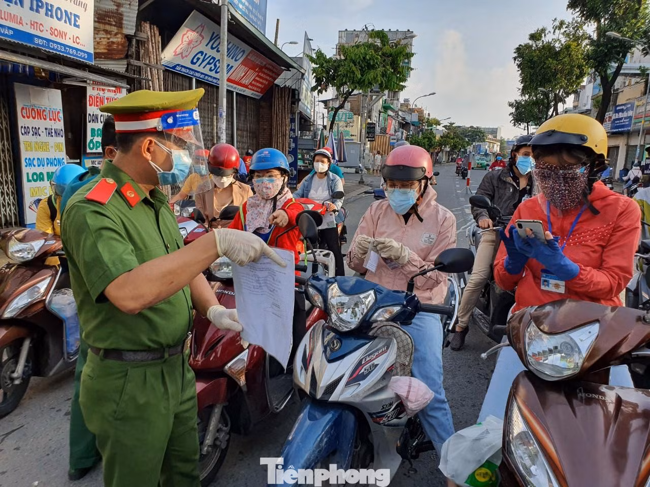 Lực lượng chức năng phổ biến giấy đi đường mới cho người dân