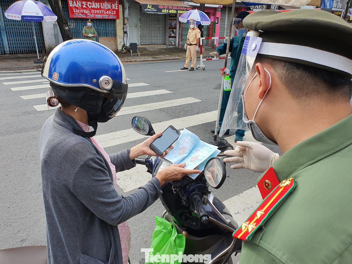 Công an đối chiếu sổ hộ khẩu của người dân