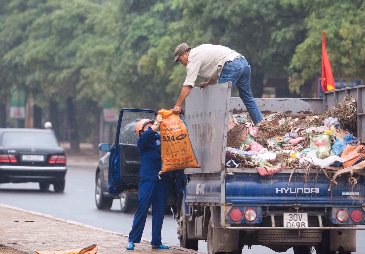 Công nhận phải liên tục vận chuyển rác lên những chiệc xe rác lưu động