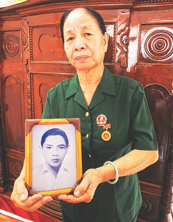 Cô Năm Lan với tấm hình anh Út Nhị tại nhà riêng. Ảnh chụp tháng 4/2023. Ảnh: Trần Nguyễn Anh