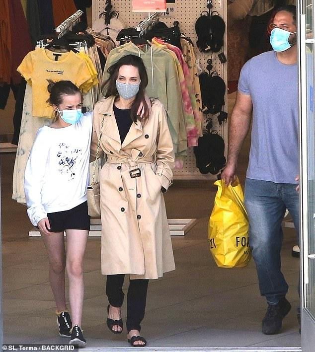 Hai mẹ con đeo khẩu trang tránh dịch COVID-19 và luôn có vệ sĩ theo sát.