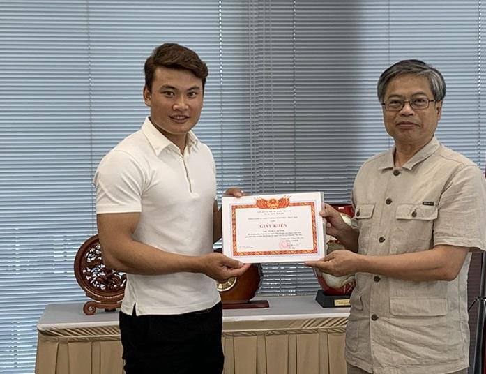 Ông Vũ Bình trao giấy khen cho anh Vũ Đức Huỳnh - Ảnh: NVCC