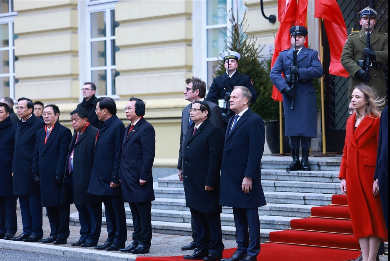 Thủ tướng Phạm Minh Chính và Thủ tướng Cộng hòa Ba Lan Donald Tusk nghe quân nhạc cử Quốc thiều hai nước. (Ảnh: Dương Giang/TTXVN)