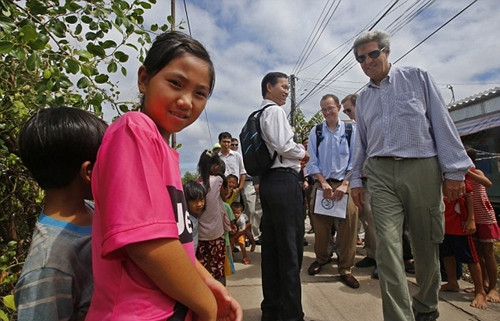 Ngoại trưởng bất ngờ ghé qua chợ Kiến Vàng, trong một chuyến thăm không báo trước. Ông mua kẹo tặng một nhóm trẻ em địa phương và khiến mọi người thích thú khi nói vài từ tiếng Việt. Ảnh: AP/Reuters Pool 