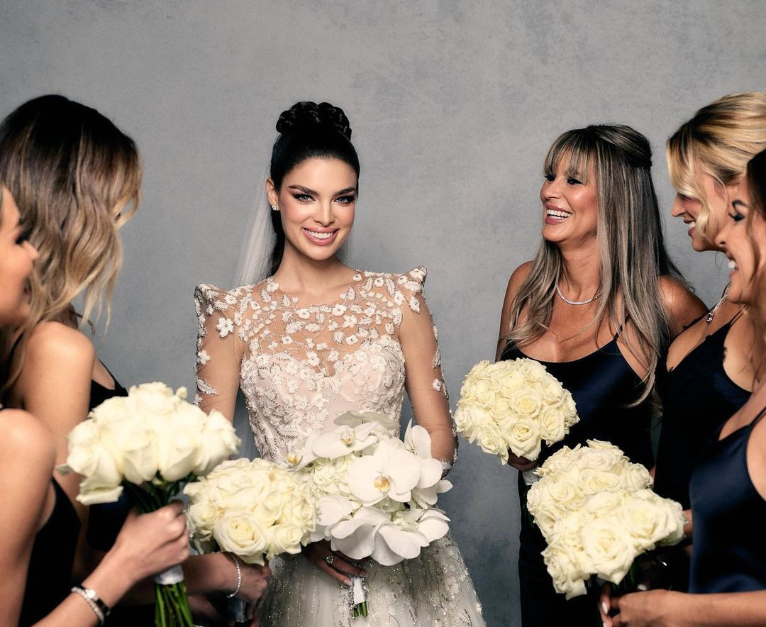 Nadia Ferreira mặc áo cưới rạng rỡ bên dàn phù dâu. Nhan sắc người đẹp Paraguay trong ngày lễ trọng đại nhận nhiều khen ngợi. Cô chọn kiểu tết tóc đuôi ngựa, trang điểm mắt khói và dùng màu son nude nhẹ nhàng.