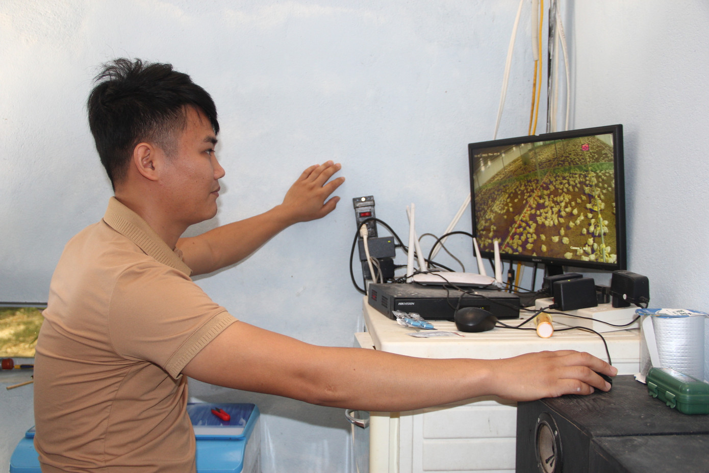 Nguyễn Văn Lâm giám sát trang trại gà từ phòng điều hành.