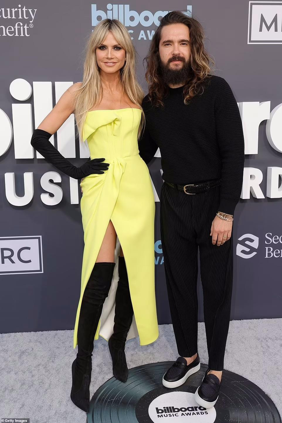Heidi Klum nổi bật khi kết hợp váy vàng với boot đen cao cổ. Cô được chồng trẻ Tom Kaulitz tháp tùng đến Billboard 2022. Heidi Klum nổi bật khi kết hợp váy vàng với boot đen cao cổ. Cô được chồng trẻ Tom Kaulitz tháp tùng đến Billboard 2022.