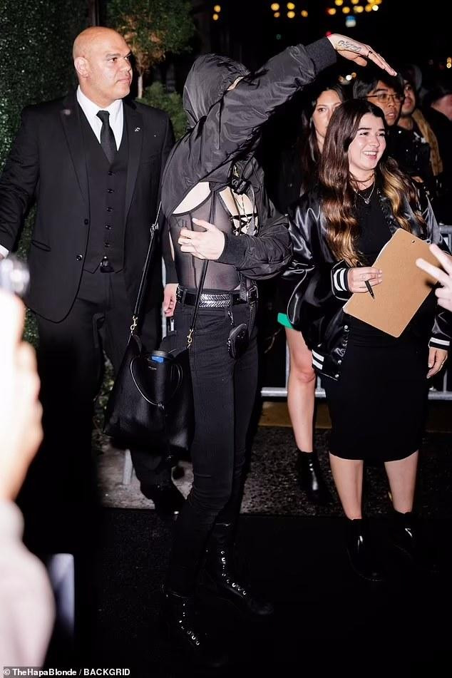 Vì mặc áo xuyên thấu, siêu mẫu Anh phải dùng tay che chắn khi chào người hâm mộ.