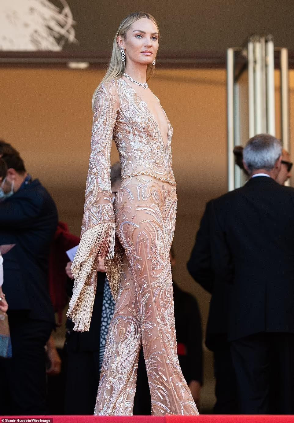 &quot;Thiên thần Nam Phi&quot; Candice Swanepoel tham dự Liên hoan phim Cannes 2021 trong bộ áo liền quần xuyên thấu với chất liệu sequins thêu và cổ xẻ sâu.