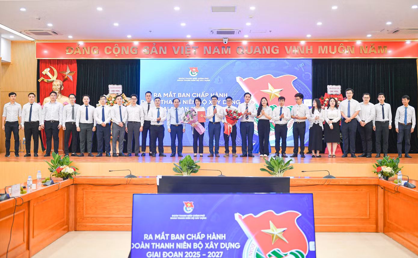 Bí thư Đoàn Thanh niên Chính phủ Bùi Hoàng Tùng và Phó Bí thư thường trực Đảng ủy Bộ, Thứ trưởng Bộ Xây dựng Nguyễn Văn Sinh trao quyết định, tặng hoa chúc mừng Ban Chấp hành Đoàn Thanh niên Bộ Xây dựng giai đoạn 2025 – 2027. Ảnh: BTC