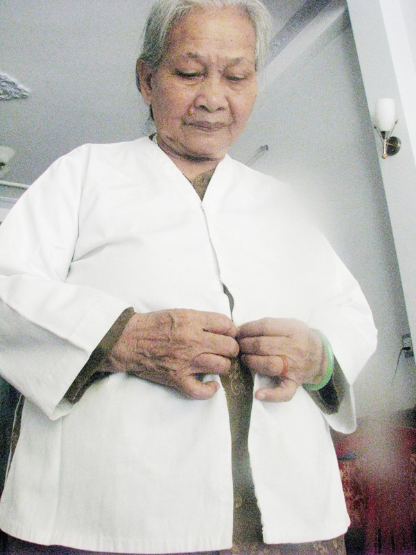 Mẹ Lê Thị Muộn với chiếc áo mang hơi ấm đứa con trai Ảnh: Tr.T 