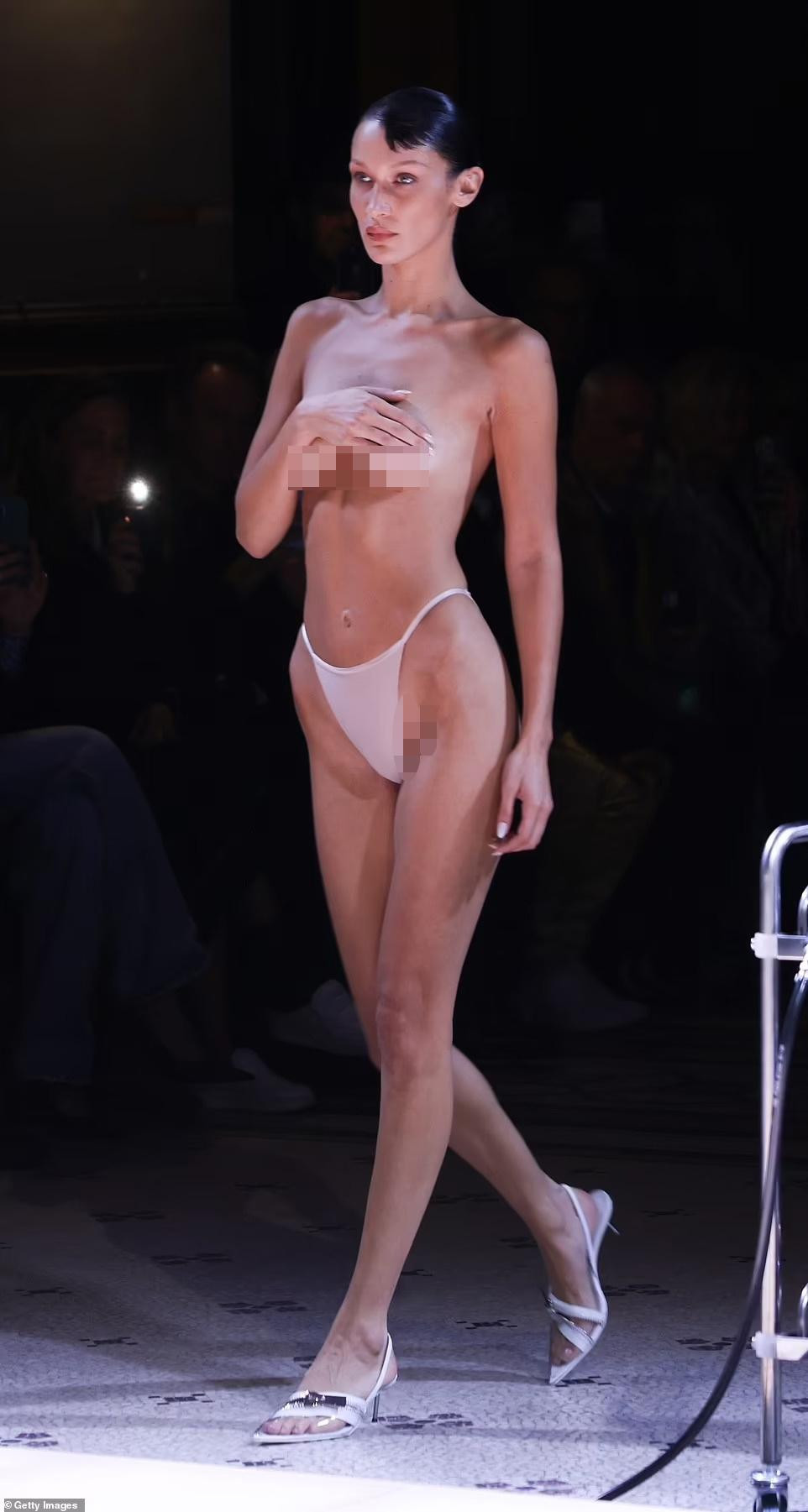 Theo Daily Mail, Bella Hadid khiến show diễn của Coperni tại Tuần lễ Thời trang 2022 vào tối 30/9 gây chú ý khi xuất hiện trên sàn catwalk trong trạng thái bán khỏa thân, chỉ mặc nội y và dùng tay che ngực trần. Ảnh: Getty Images.