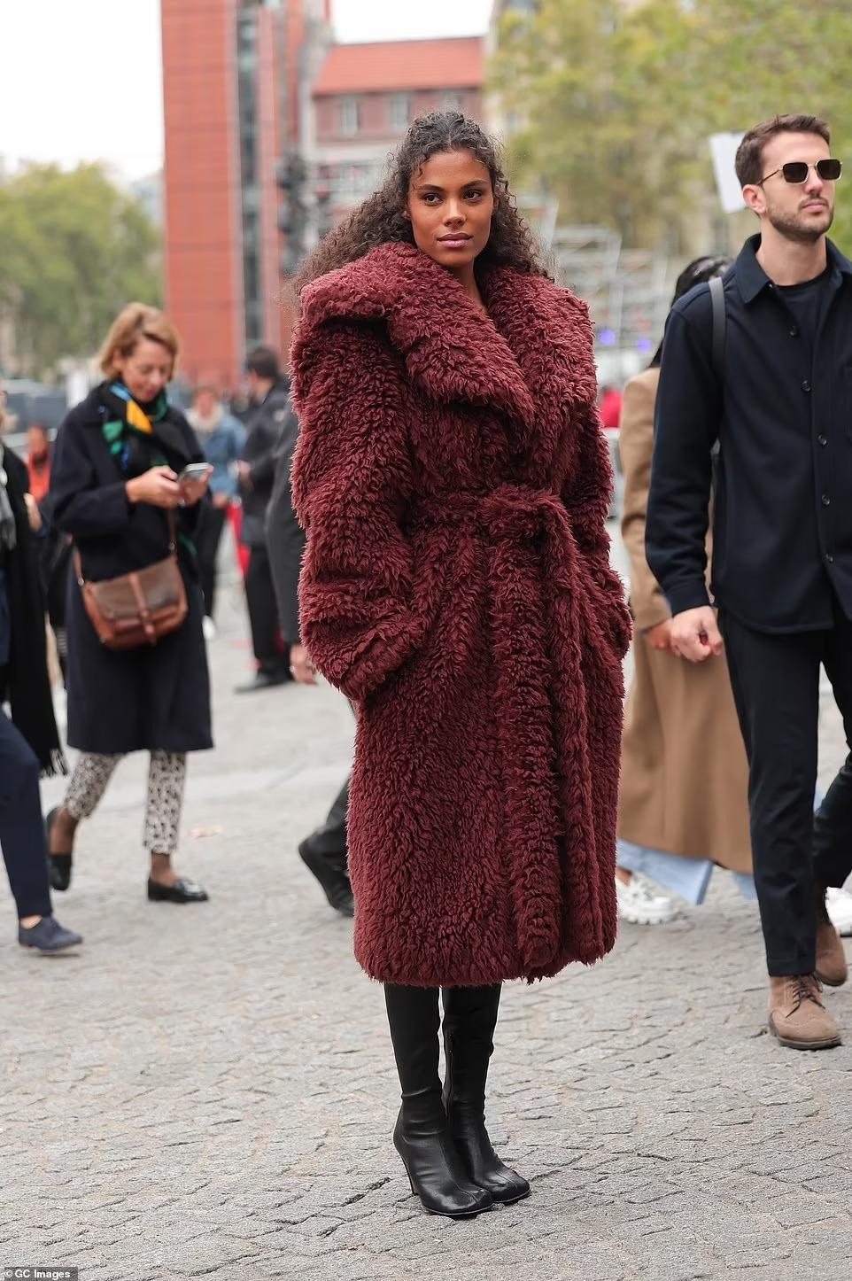 Nữ diễn viên Tina Kunakey khoác lên mình chiếc áo khoác đỏ tía xù xì.