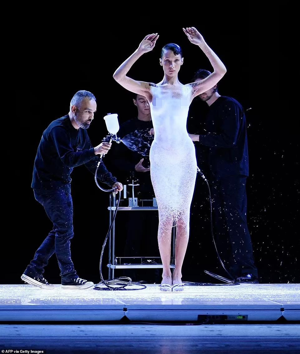 Chiếc váy liền thân dần hình thành trên cơ thể Bella trước sự chứng kiến của đông đảo khách mời. Ảnh: Getty Images.