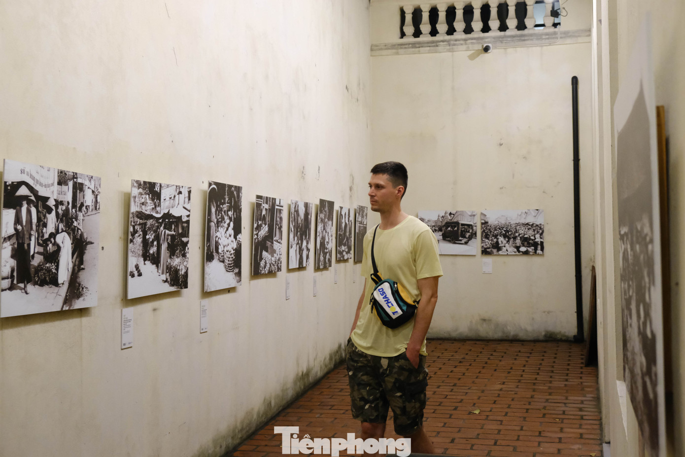 Du khách quốc tế chăm chú quan sát những bức ảnh phóng sự xuất hiện tại điểm đến văn hoá ở phố Hàng Buồm, Hà Nội.