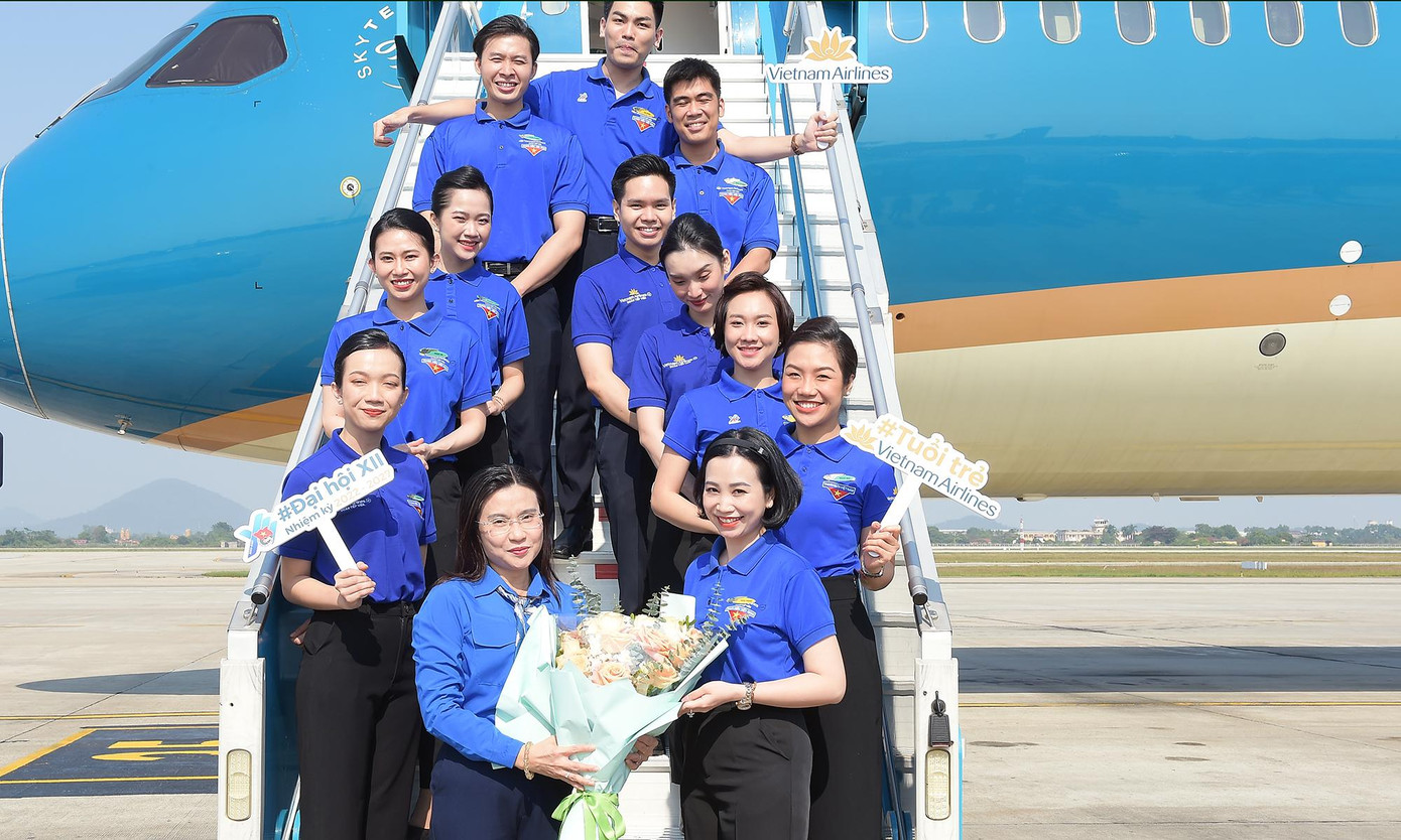 Chị Nguyễn Phạm Duy Trang tặng hoa đoàn viên thanh niên Vietnam Airlines phục vụ trên chuyến bay. Ảnh: Xuân Tùng