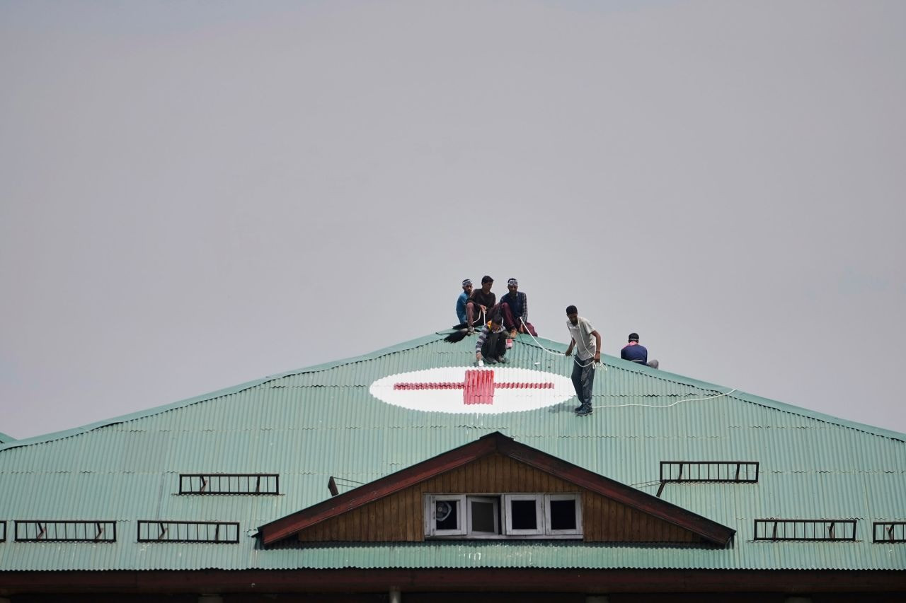 Các công nhân sơn biểu tượng y tế màu đỏ và trắng trên mái của một bệnh viện ở ngoại ô Srinagar, thuộc vùng Kashmir do Ấn Độ quản lý. (Ảnh: AP)