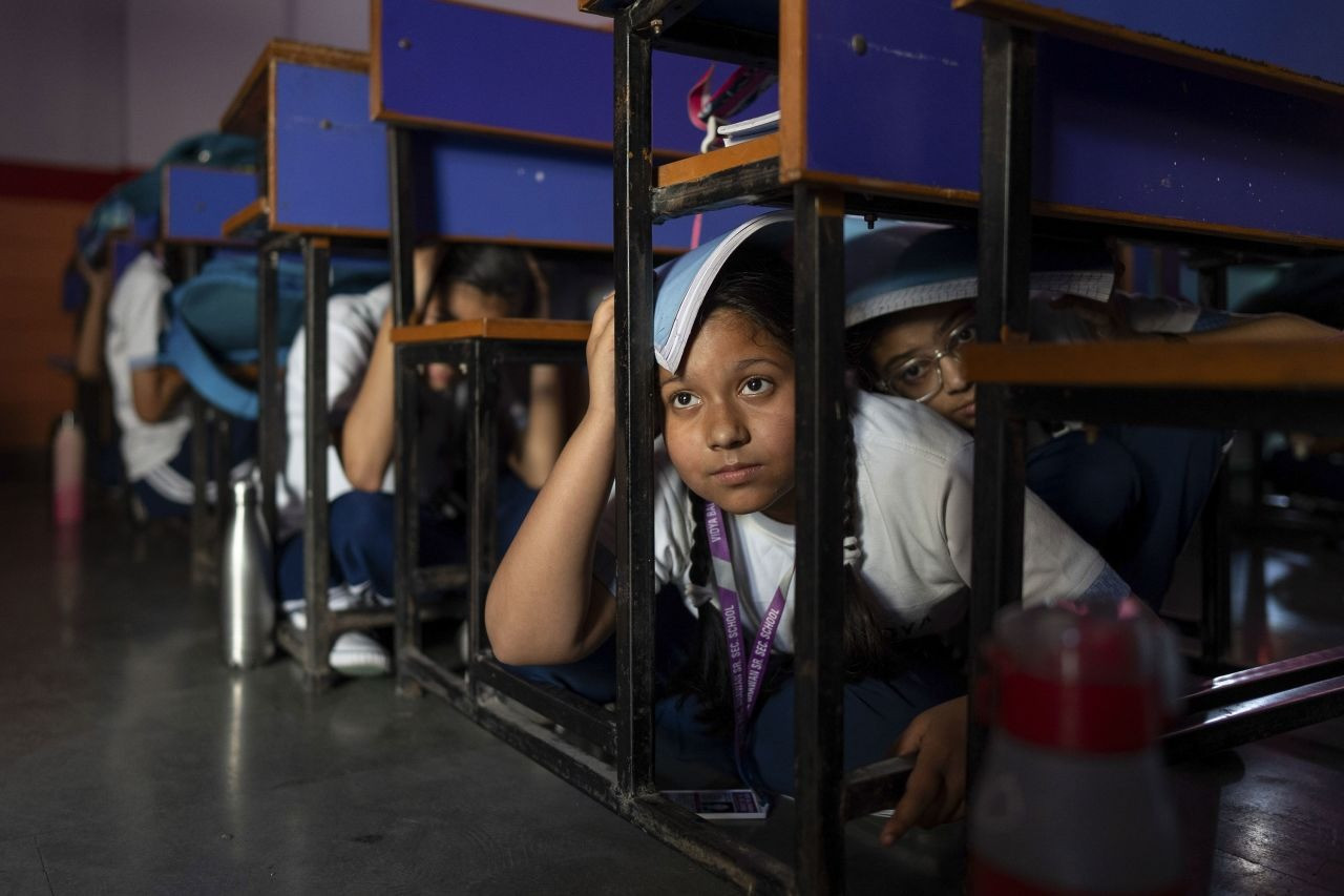 Học sinh New Delhi trốn dưới gầm bàn trong cuộc tập trận phòng thủ sáng 7/5. (Ảnh: Anadolu)