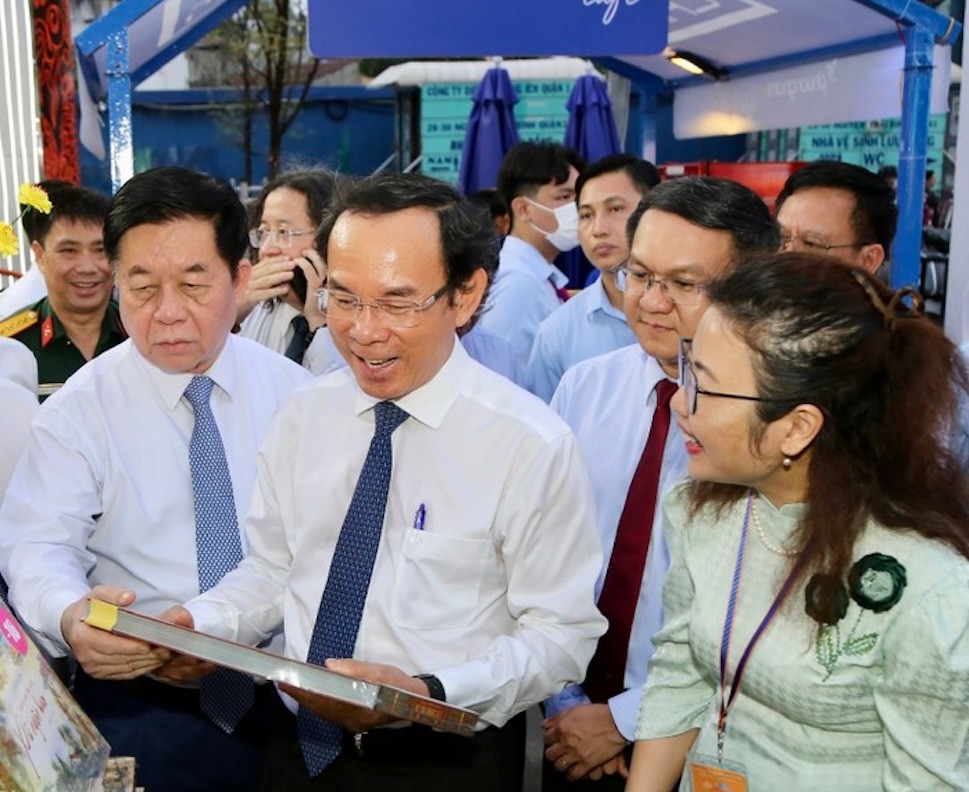 Ông Nguyễn Văn Nên - Bí thư Thành Uỷ TPHCM (giữa) và ông Nguyễn Trọng Nghĩa - Trưởng Ban Tuyên giáo Trung ương cùng các đại biểu tham quan một gian hàng sách điện tử.