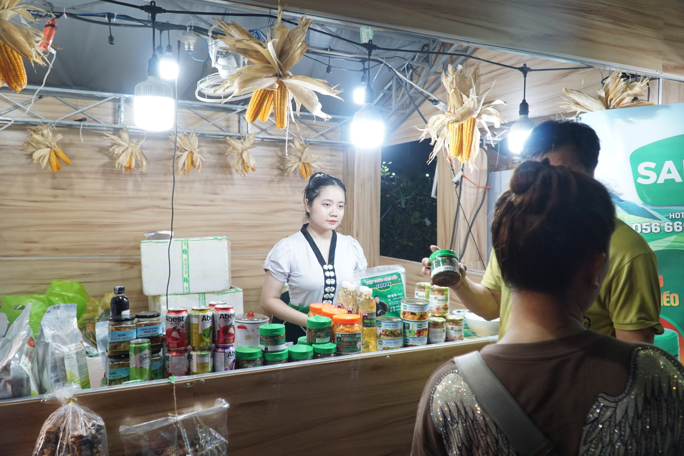 Cô gái trong trang phục dân tộc Thái đang giới thiệu thức uống thảo mộc vùng Tây Bắc