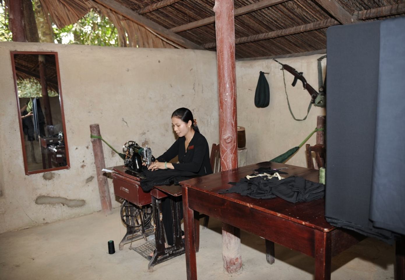 Hình ảnh một nữ du kích đang may quần áo trong hầm trú ẩn Hình ảnh một nữ du kích đang may quần áo trong hầm trú ẩn