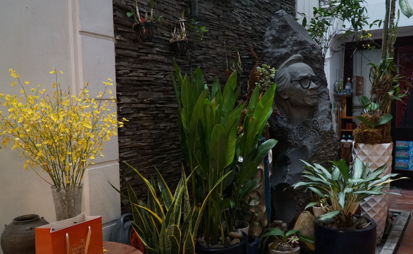 Hoa và cây xanh bên phù điêu của nhạc sĩ Trịnh Công Sơn.