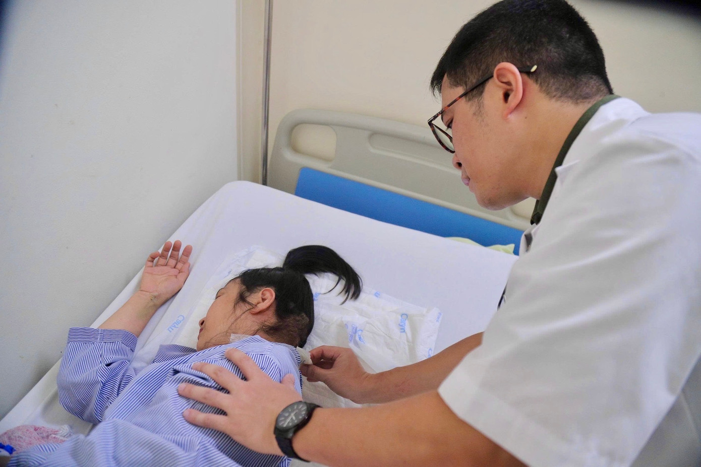 Bác sĩ kiểm tra vết thương sau phẫu thuật cho bệnh nhân T. Ảnh: Bệnh viện K