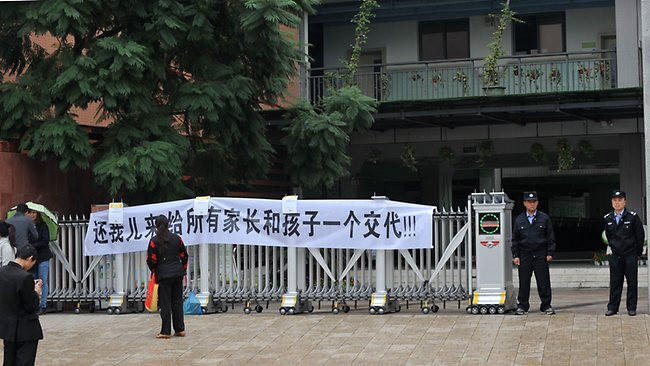 Cha mẹ em căng biểu ngữ: "Trả lại con cho chúng tôi, giải thích với tất cả phụ huynh và học sinh!". Cha mẹ em căng biểu ngữ: