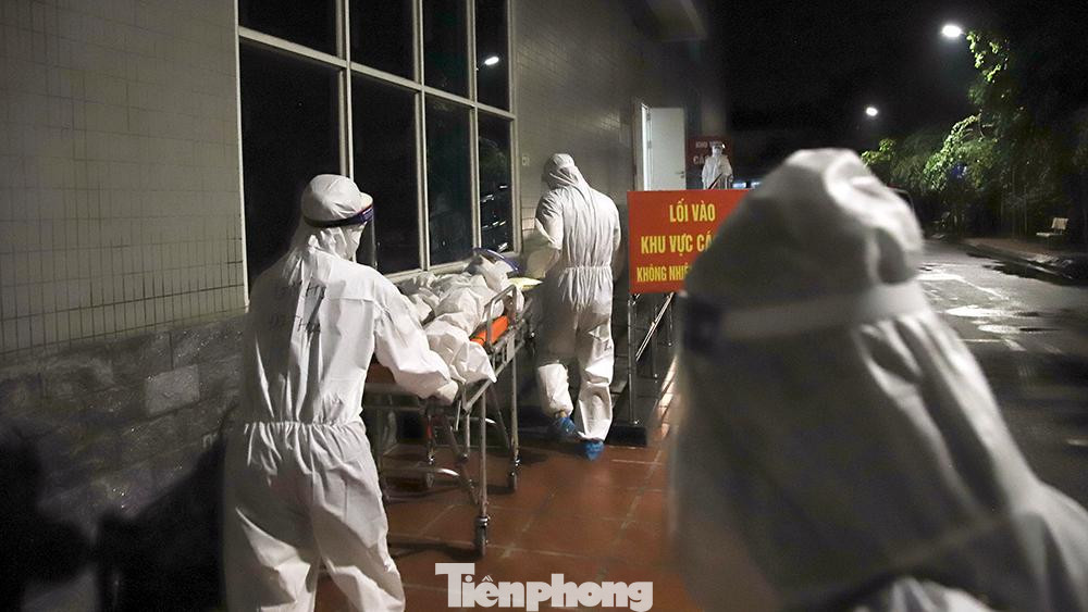 Từ 20h tối (4/10), Bệnh viện Thanh Nhàn tiếp nhận những bệnh nhân đầu tiên. Trước khi xuống xe, các nhân viên y tế hỗ trợ người dân vận chuyển đồ đạc mang theo và kiểm tra đủ danh sách người.