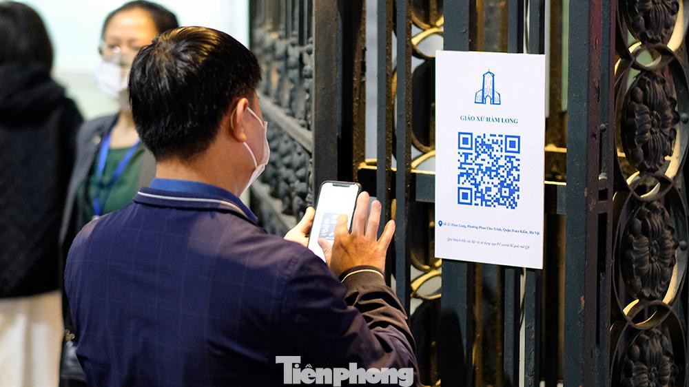Những người có giấy mời dự, quét mã QR code để khai báo y tế, đo thân nhiệt mới được vào nhà thờ dự lễ.