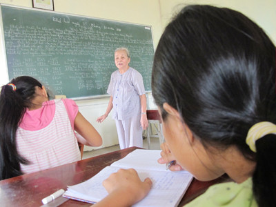 Bà Tư đang dạy chữ cho trẻ nghèo. Ảnh: Nguyễn Hiền