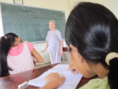 Bà Tư đang dạy chữ cho trẻ nghèo. Ảnh: Nguyễn Hiền