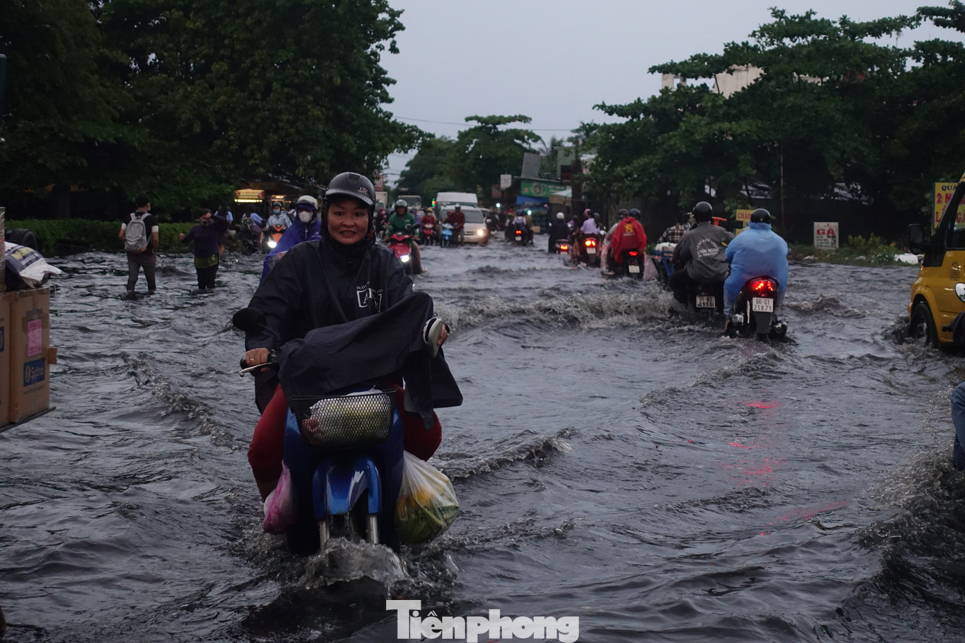 Người dân bì bõm trong dòng nước đen.