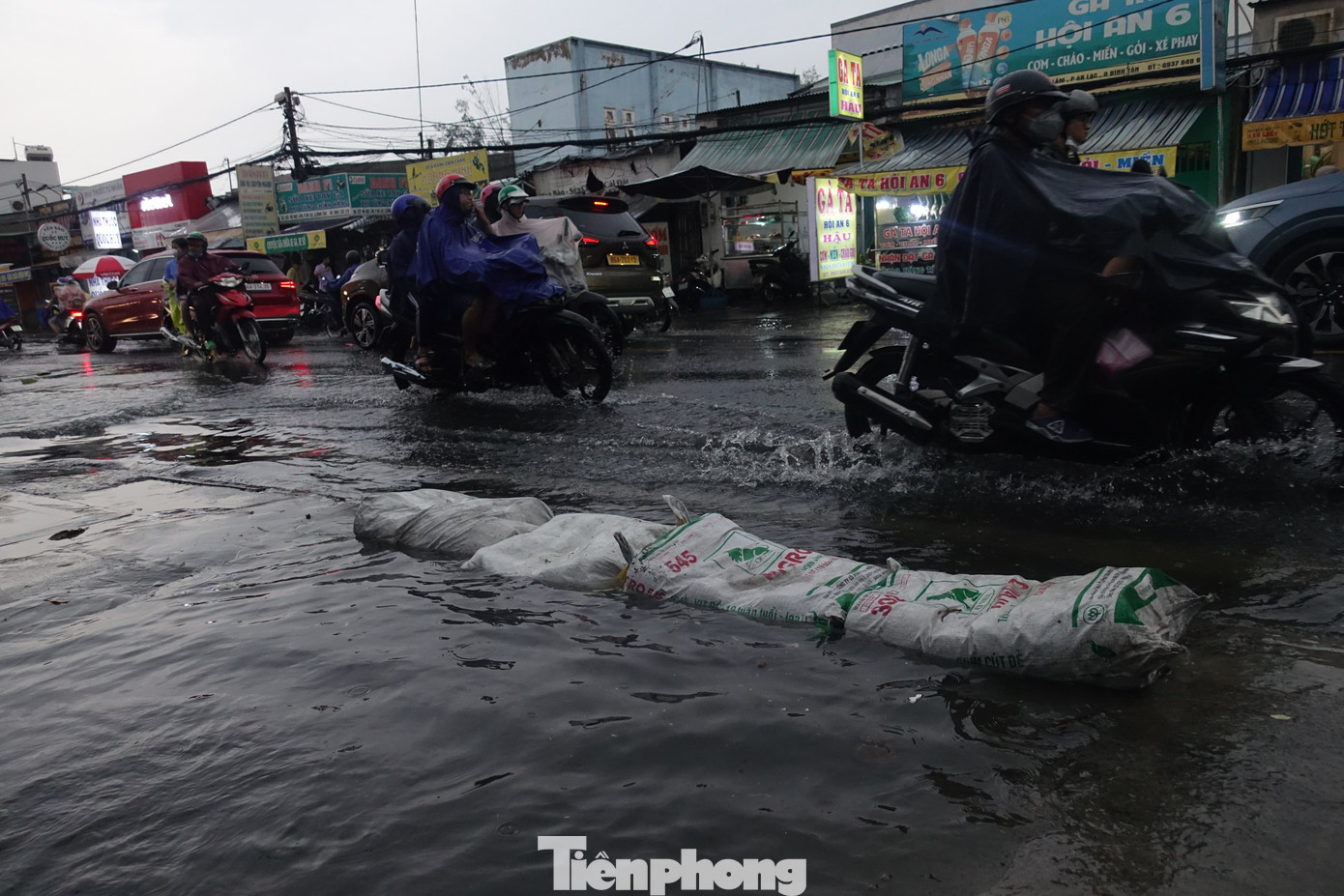 Người dân tại một con hẻm trên đường Hồ Ngọc Lãm (quận Bình Tân) dùng bao cát để ngăn nước.