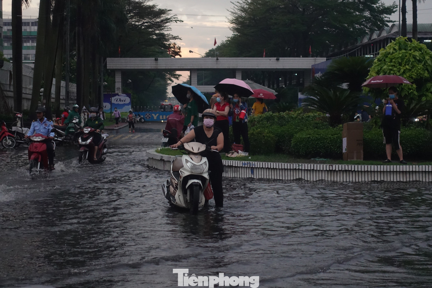 Công nhân bì bõm lội nước về nhà sau giờ tan ca.