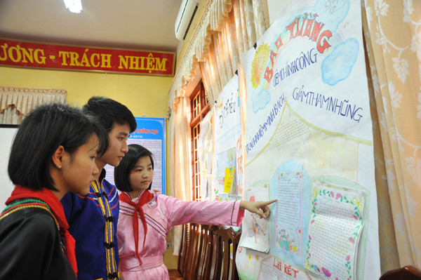 Các học sinh trường TPDT Nội trú Nguyễn Bỉnh Khiêm, Võ Nhai, Thái Nguyên bên tờ báo tường có chủ đề Liêm Chính Công