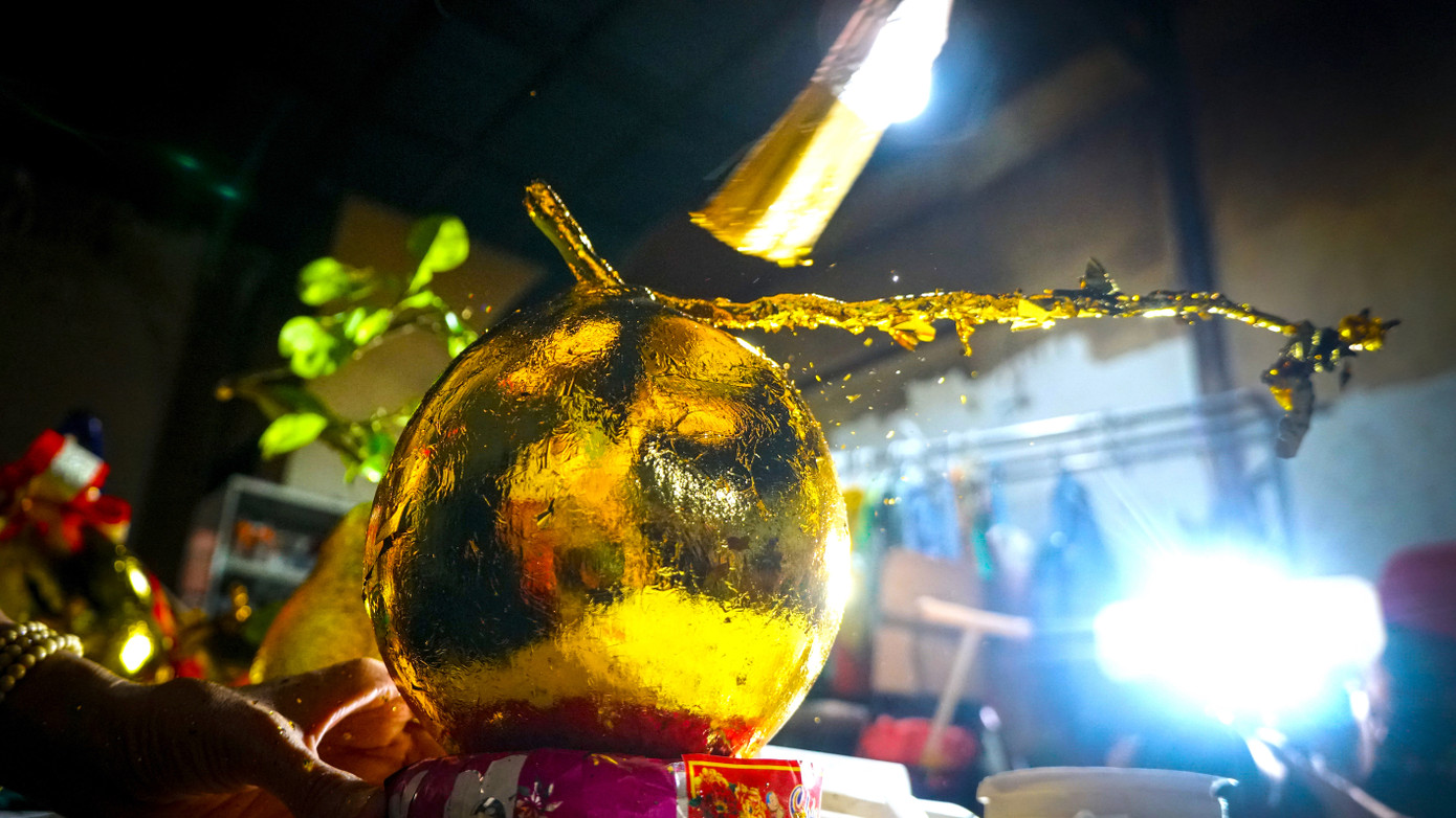 Dùng cọ phủ lá vàng dư để tạo độ bóng đẹp cho trái dừa.