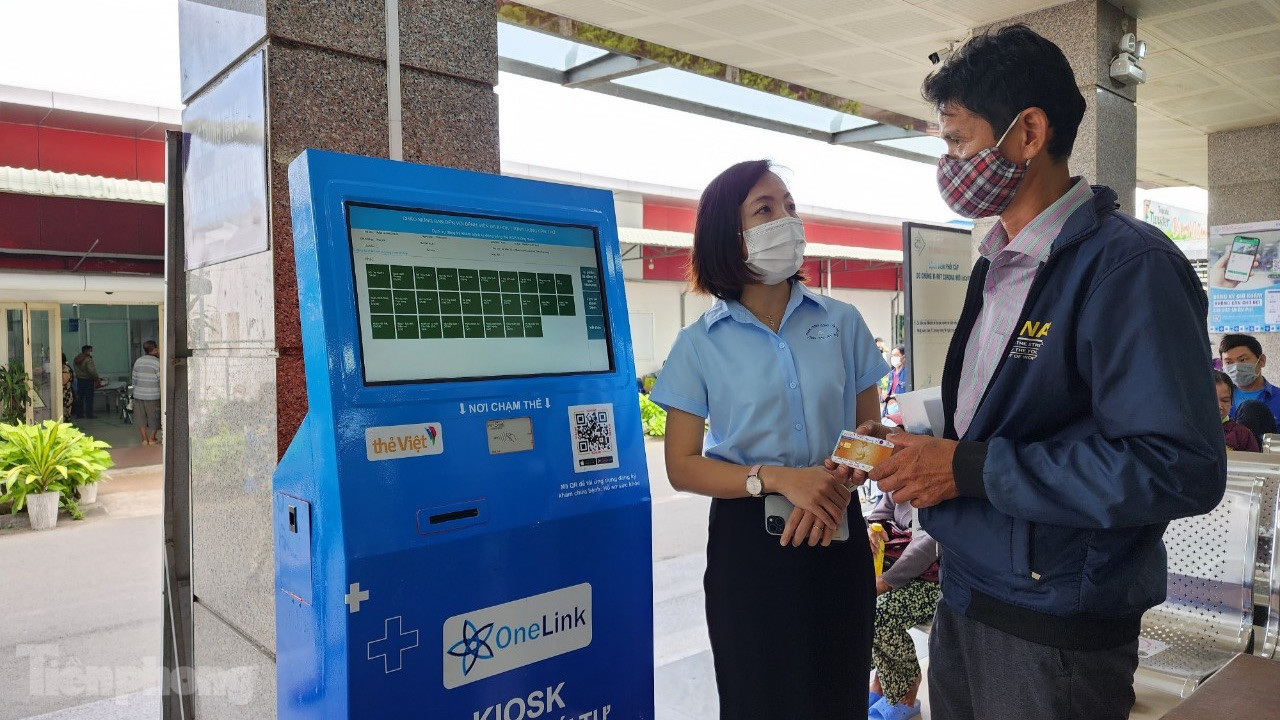 Nhân viên bệnh viện hướng dẫn người dân sử dụng thẻ y tế thông minh. Ảnh: Kim Hà.