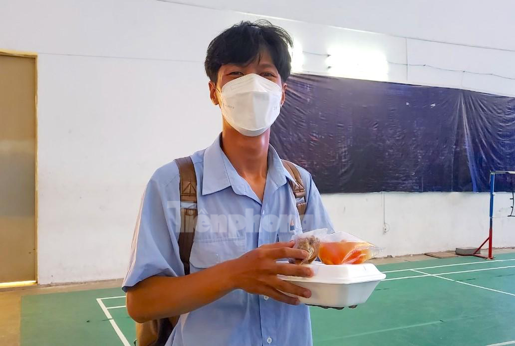 Một thí sinh phấn khởi nhận cơm sau khi làm bài thi - Ảnh: Kim Hà.