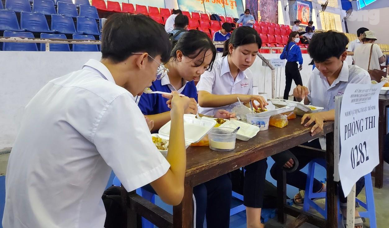 Vừa ăn cơm, các thí sinh phấn khởi chia sẻ: “Tụi em thấy đề văn năm nay tương đối vừa sức. Phần nghị luận xã hội nói về tuổi trẻ, rất sát với thực tế. Vì trong đợt dịch COVID-19 vừa qua, tụi em cũng tham gia đi tình nguyện, chung tay với các anh chị cùng chống dịch. Qua đó, thấy trách nhiệm của người trẻ đối với đất nước” - Ảnh: Kim Hà.