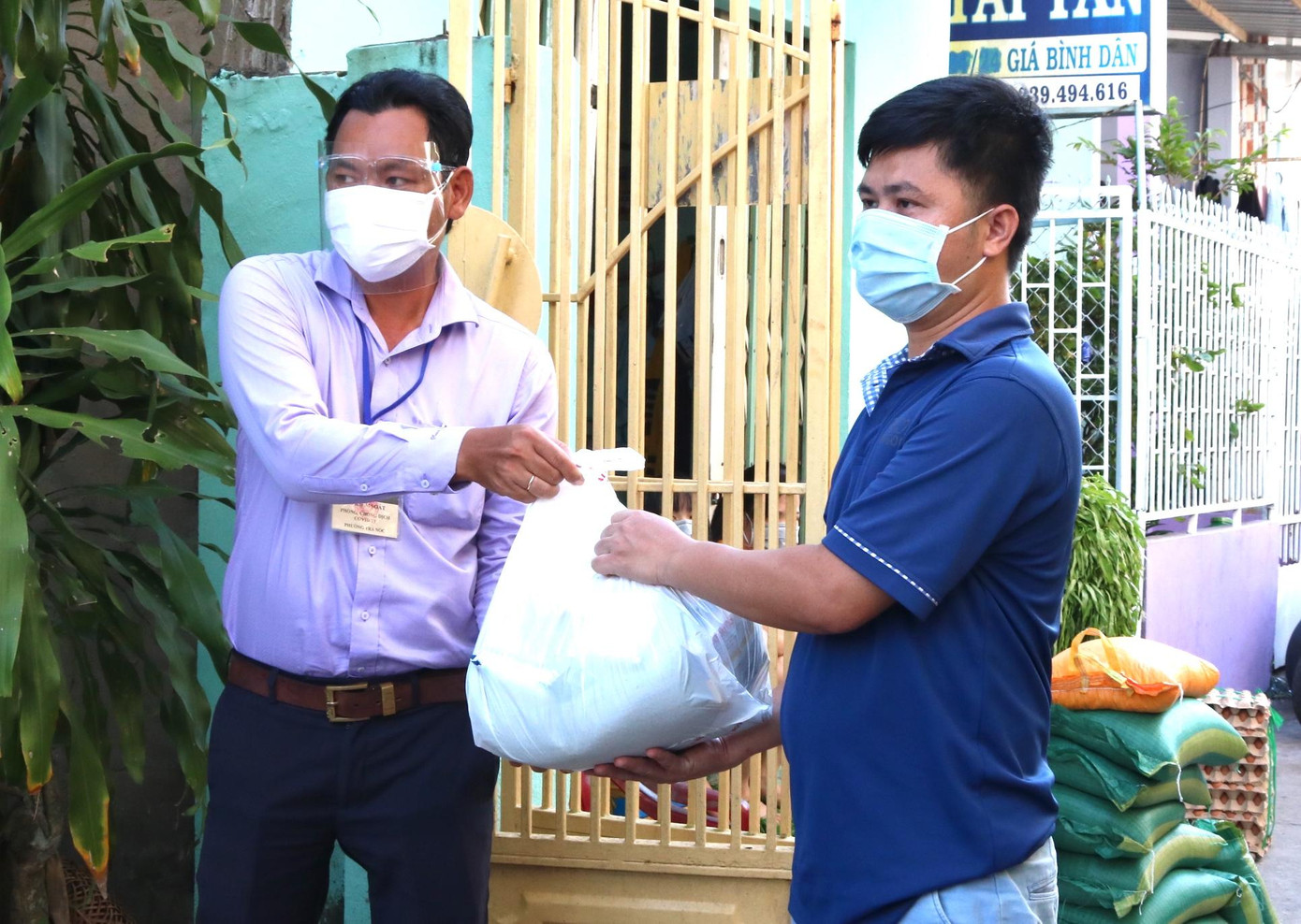 Ông Đặng Hoàng Định - Phó Chủ tịch phường Trà Nóc trao các suất quà là nhu yếu phẩm cần thiết đến tay bà con xóm trọ công nhân - Ảnh: Kim Hà.