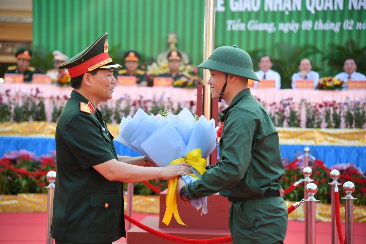 Thiếu tướng Phạm Trường Sơn - Phó Tổng Tham mưu trưởng QĐND Việt Nam tặng hoa cho thanh niên trong lễ giao nhận quân tại Tiền Giang.
