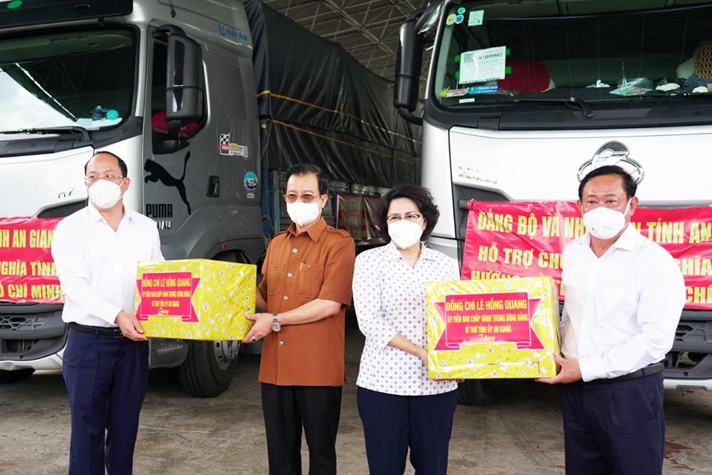 Ông Nguyễn Hồ Hải - Phó Bí thư Thành uỷ TP Hồ Chí Minh thay mặt nhân dân thành phố tiếp nhận quà từ ông Lê Hồng Quang - Bí thư Tỉnh uỷ An Giang (áo nâu).